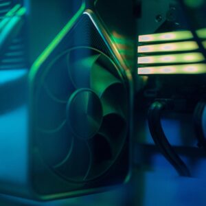 Detailed close-up of a computer cooling fan inside a custom PC with LED lighting, emphasizing technology and design.